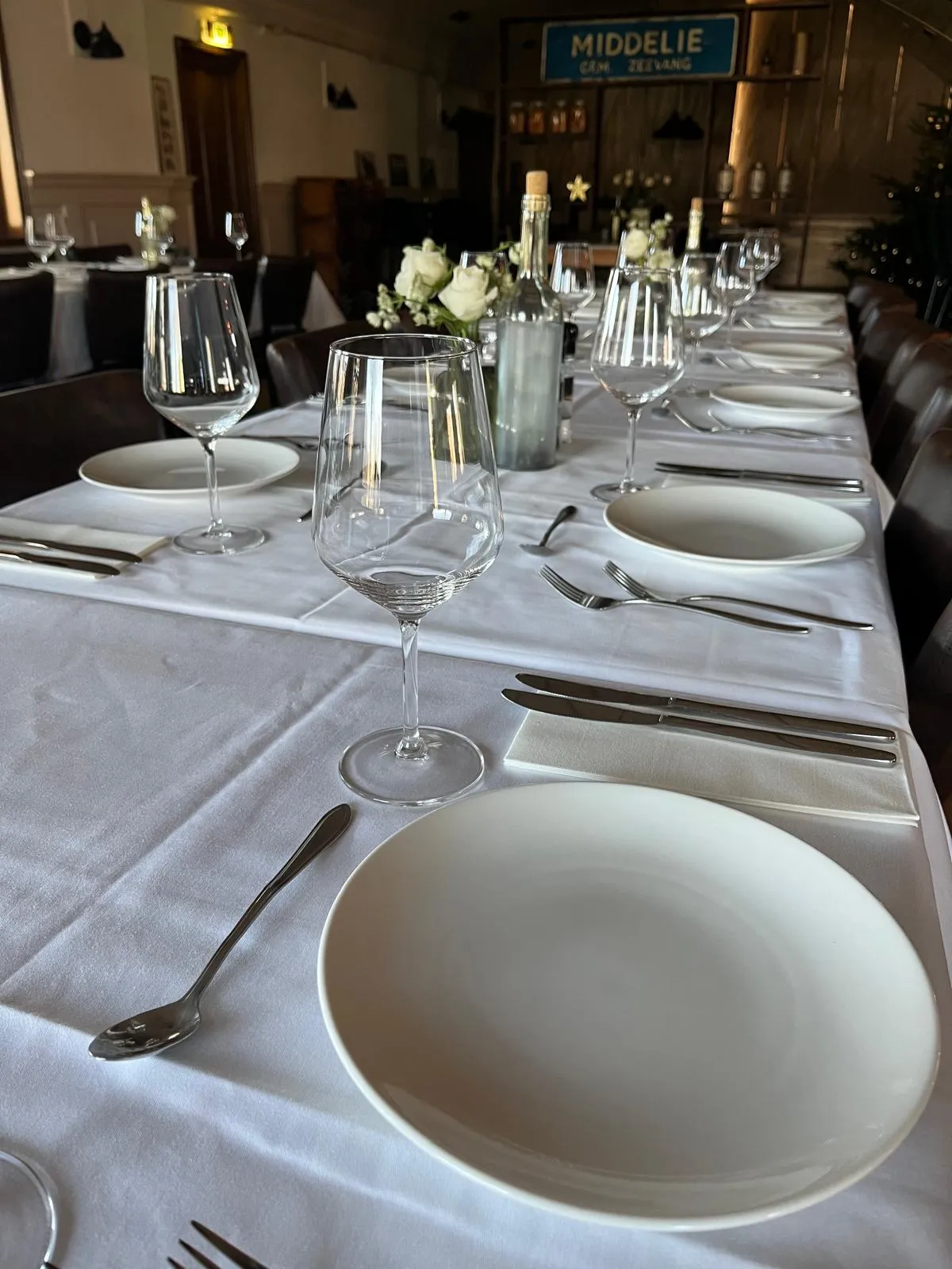 Een feestelijk gedekte tafel met wijnglazen en bloemen in het restaurant