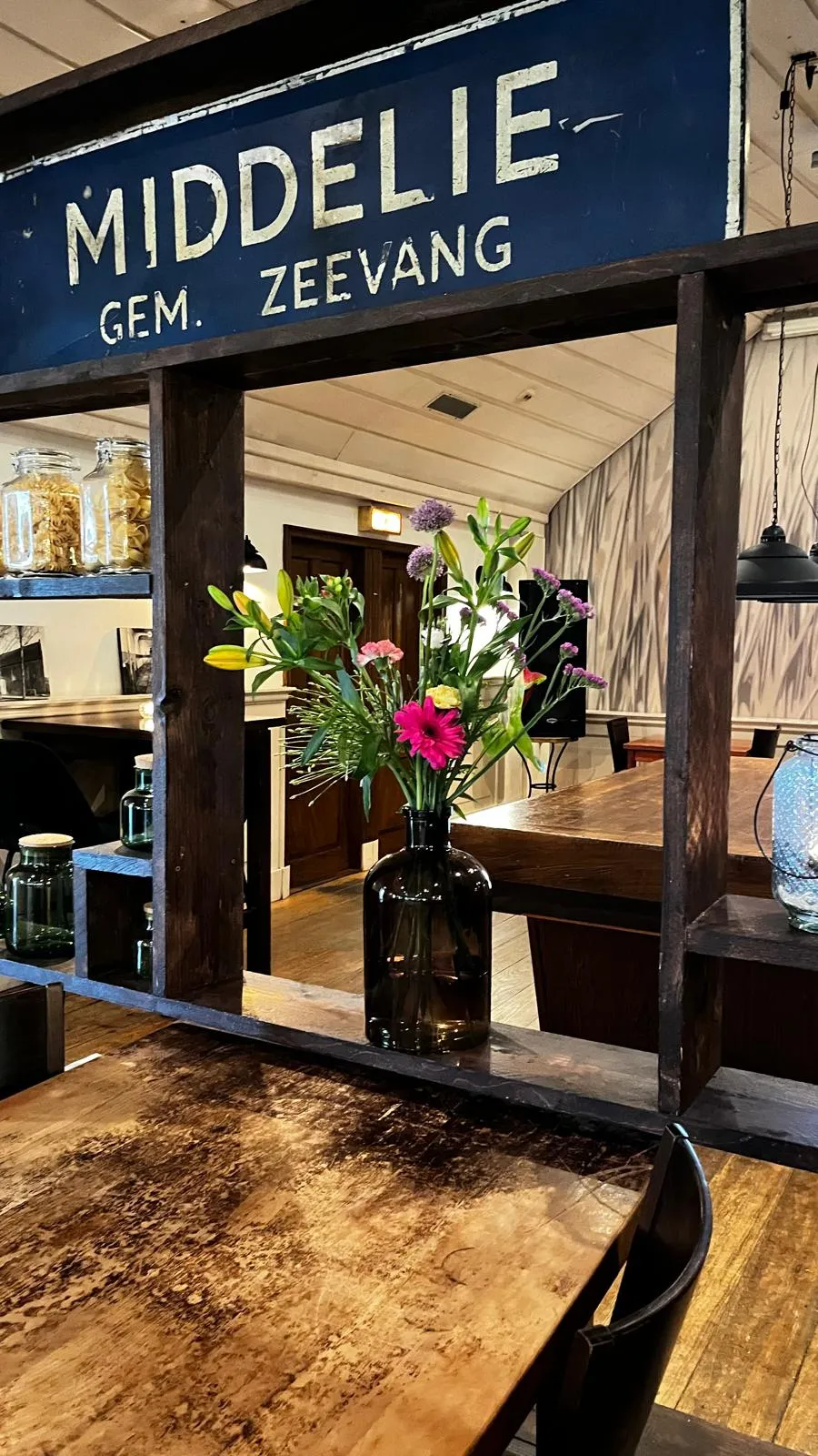 Bloemen op de houten bar onder het historische bord Middelie, gem. Zeevang